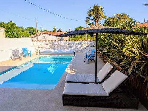 - une piscine avec des chaises et un parasol à côté de la piscine dans l'établissement MAISON 6 PERS PROCHE DE LA MER, à Lussant