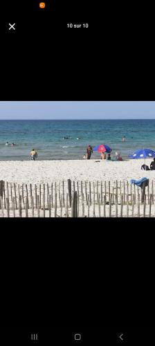 a picture of a beach with chairs and umbrellas at Najla in Hergla