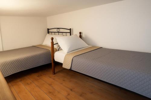 two beds sitting next to each other in a room at Eleni's Traditional Home with Barbeque in Zarós