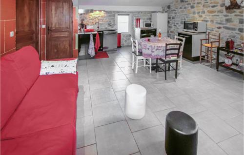 グロスピエールにあるAwesome Home In Grospierres With Saunaの赤いソファとキッチンのあるリビングルーム