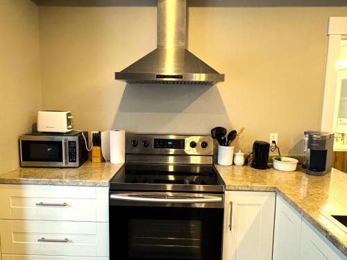 a kitchen with a stove and a microwave at Dominion Place in Moncton