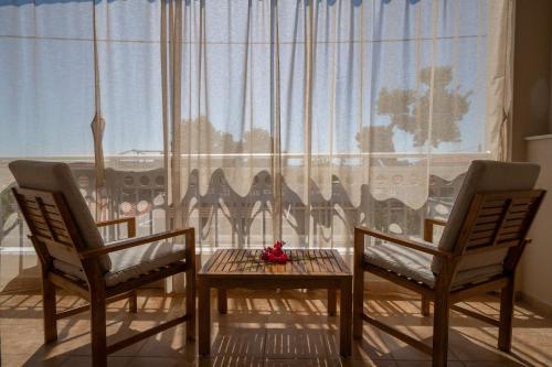 two chairs and a table in front of a window at Casa Luna in Patitiri