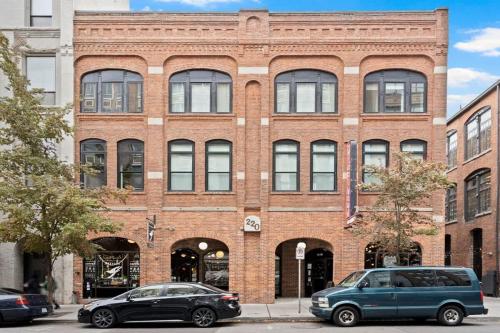 two cars parked in front of a brick building at Stunning 3-Bed Retreat in the Heart of Downtown in Spokane