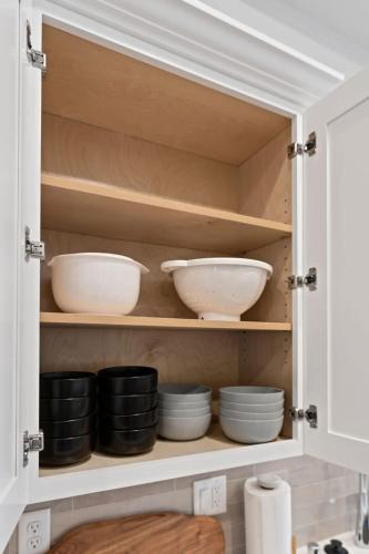 a cupboard with bowls and plates in it at Stunning 3-Bed Retreat in the Heart of Downtown in Spokane
