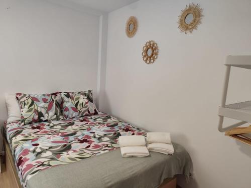 een bed in een kamer met een witte muur bij Casinha da Marina - totalmente renovada in Nazaré
