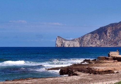 a view of the ocean with a mountain in the background at Mary's House in Iglesias