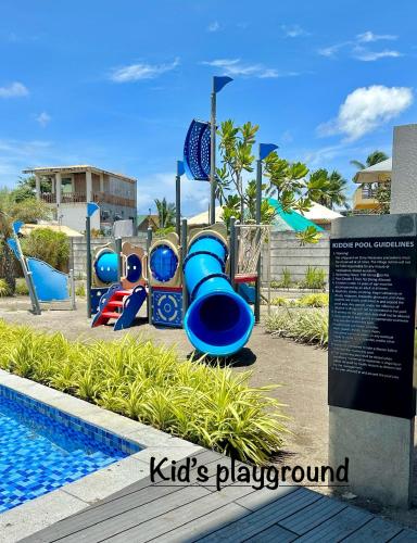 a playground with a water slide next to a pool at The Calm Nest by Luke and Nian in San Juan