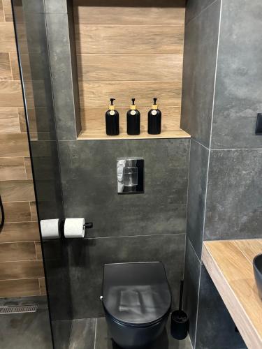 a bathroom with a black toilet and a sink at Апартамент САМИ in Dobrich