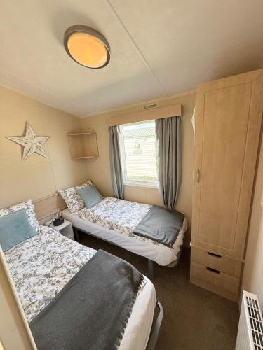 a small room with two beds and a window at Skigh Cabin in St. Andrews