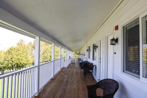 a porch with chairs and windows on a house at The Water Street Inn in Ephraim