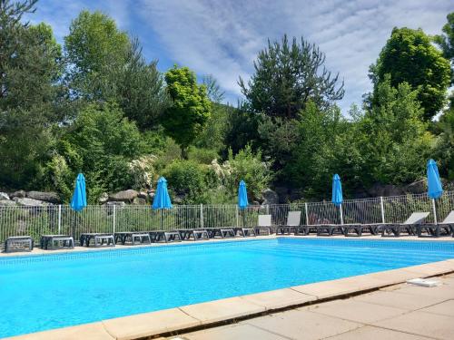 - une piscine avec des parasols et des chaises bleus dans l'établissement Le Litano, à lʼÉgaye