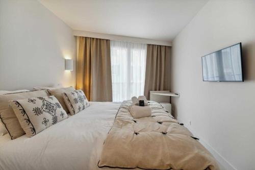 ein Schlafzimmer mit einem großen weißen Bett mit einem großen Fenster in der Unterkunft Chic 2BR 4P Apartment Saint-Tropez Lices in Saint-Tropez