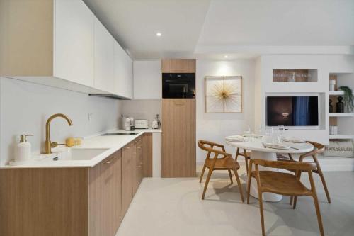 une cuisine avec une table, des chaises et un évier dans l'établissement Chic 2BR 4P Apartment Saint-Tropez Lices, à Saint-Tropez