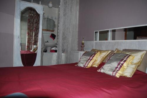 een slaapkamer met een groot bed met rode lakens en kussens bij Villa Paul in Blankenberge