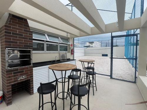 Prime Beach house Aracaju في أراكاجو: مطبخ مع طاولات وكراسي في مطبخ به نوافذ