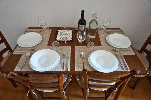 a wooden table with white plates and wine glasses at Casa dell'angelo labaro in Rome