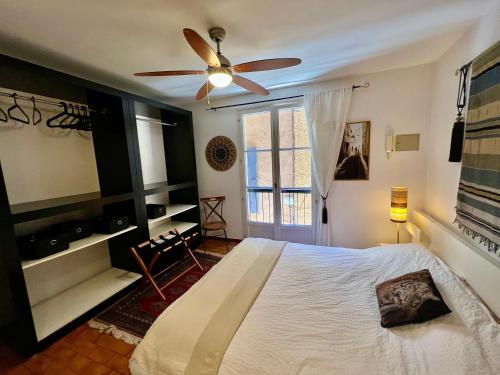 a bedroom with a bed and a ceiling fan at Maison des Remparts in Céret