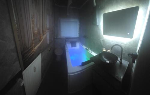 a small bathroom with a sink and a light at Little Paradise Spa Appartement in Gummersbach