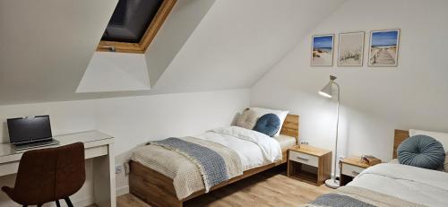 a bedroom with a bed and a desk with a tv at Baltic Harmony Villas - Grzybowo in Grzybowo