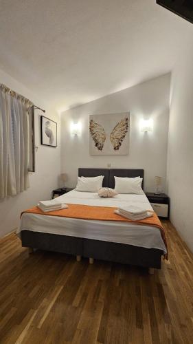 a bedroom with a large bed with an orange blanket at Charming Villa Katja with Private Pool and AC in All Rooms, Near Split in Omiš