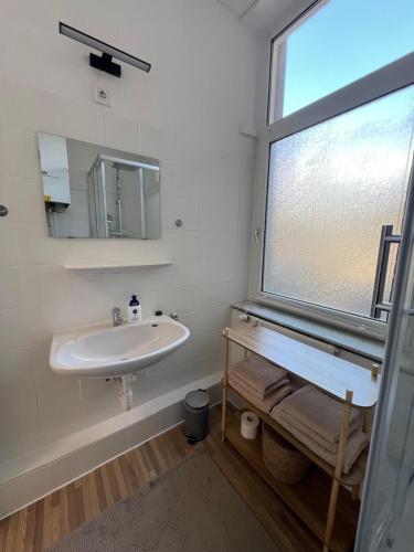 a white bathroom with a sink and a window at City Studio Apartment im Erdgeschoss Ground floor Near it all in Neuss