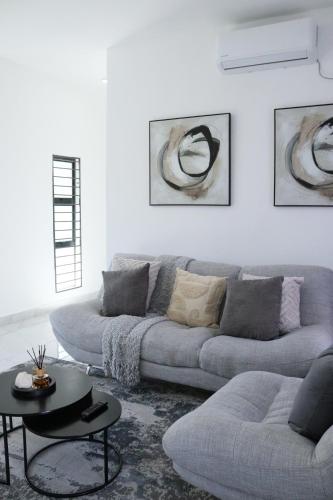 a living room with a couch and a table at ThreeOn10 - Modern Luxury Apartment in Gaborone