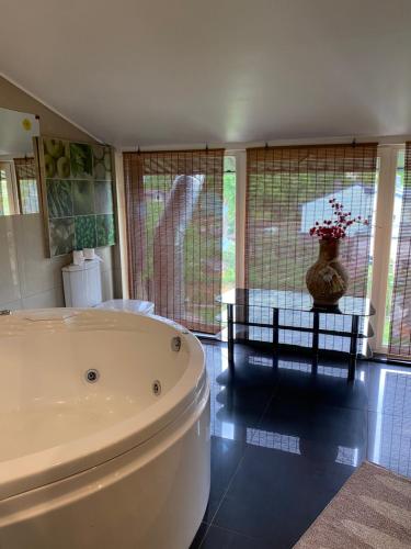a bathroom with a tub and a table with a vase at Easy Stay Apartments in Rīga