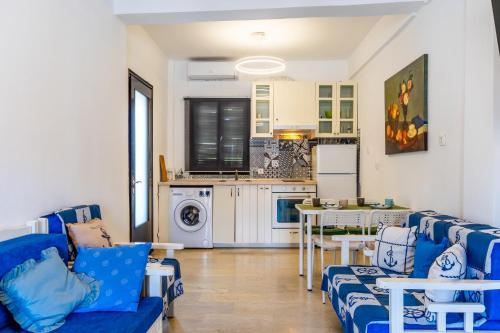 a living room with blue couches and a kitchen at Sunrise Pefkochori in Pefkohori
