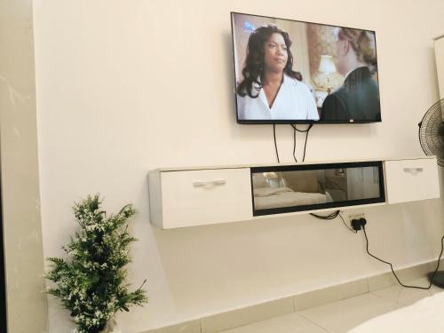 Un televisor de pantalla plana colgado en una pared en Graciano Suit's, en Lagos