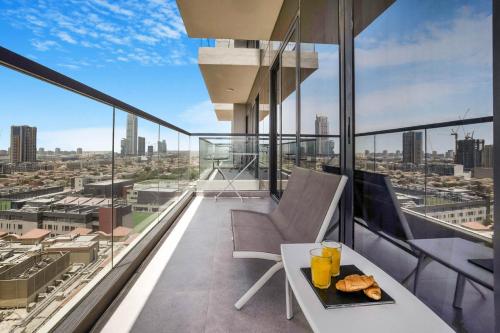 a balcony with a table with a plate of food on it at Comfy 1BR w Cinema Room Business Centre Pool Table and Sauna in Dubai