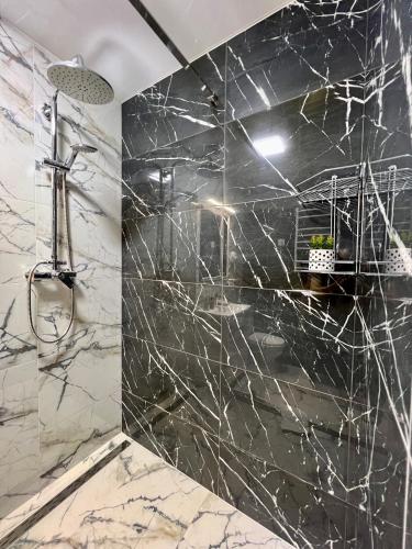 a bathroom with black and white marble walls and a shower at apartments in Ternopil city in Ternopilʼ