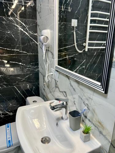 a bathroom with a sink and a mirror and a toilet at apartments in Ternopil city in Ternopilʼ