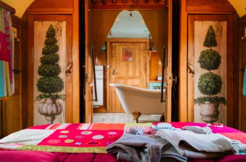 a bedroom with a bed and a tub and a bathroom at Magnifique Roulotte Bohème 1930 in Mézos