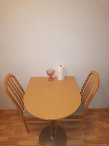 a table with two chairs and a roll of toilet paper on it at Yksiö upealla järvinäkymällä Termessä in Ikaalinen