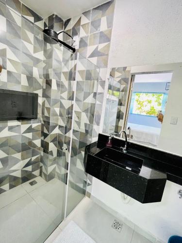 a bathroom with a black sink and a mirror at CASINHA JASMIM, vila florescer, centro histórico!! in Piranhas