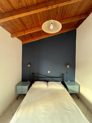 a bedroom with a bed with two blue night stands at Maroulios Apartment in Elafonisos