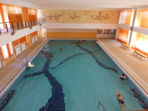a large indoor swimming pool with people in it at Hotel Doina in Neptun