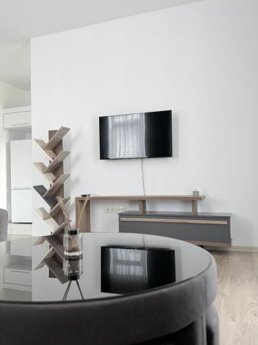 a living room with a table and a tv at green diamond 3 bedroom in Tbilisi City