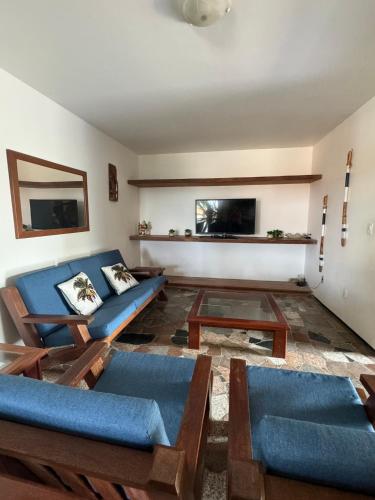 a living room with blue couches and a table at Villa Jaguaribe in Fortim
