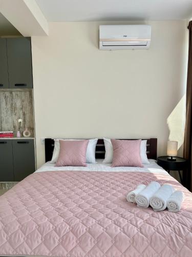 a bedroom with a pink bed with two towels on it at apartments in Ternopil city in Ternopilʼ