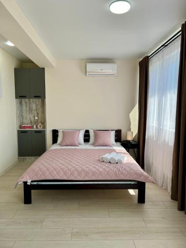 a bedroom with a large bed with pink sheets at apartments in Ternopil city in Ternopilʼ