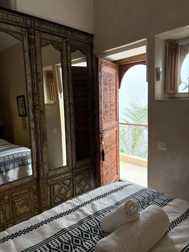 a bedroom with a bed with a mirror and an open door at Riad la Cigale in Marrakech