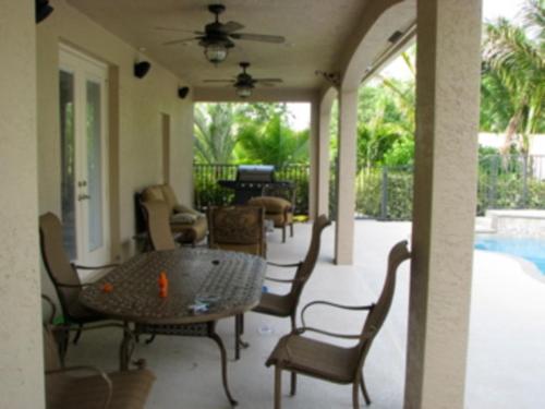 a patio with a table and chairs and a pool at jupiterholidays in Jupiter