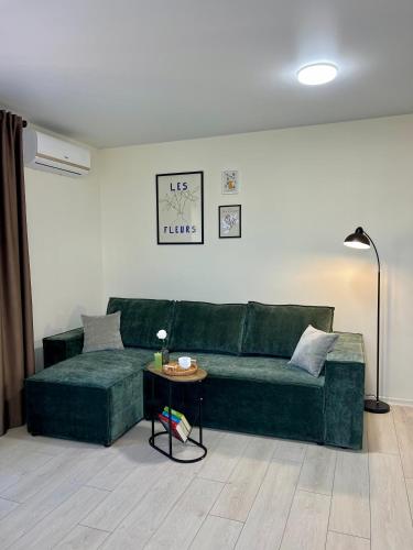 a living room with a green couch and a table at apartments in Ternopil city in Ternopilʼ