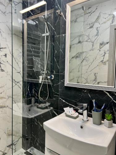 a bathroom with a white sink and a shower at apartments in Ternopil city in Ternopilʼ