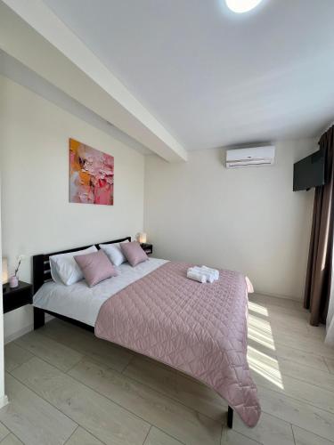 a bedroom with a large bed with pink pillows at apartments in Ternopil city in Ternopilʼ
