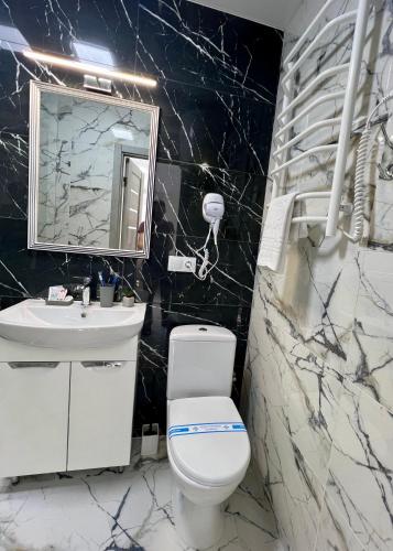 a bathroom with a toilet and a sink and a mirror at apartments in Ternopil city in Ternopilʼ