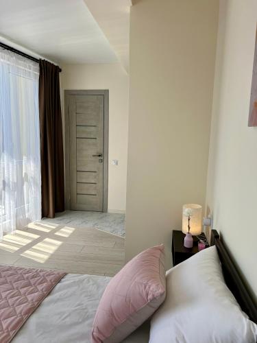 a bedroom with a bed and a large window at apartments in Ternopil city in Ternopilʼ