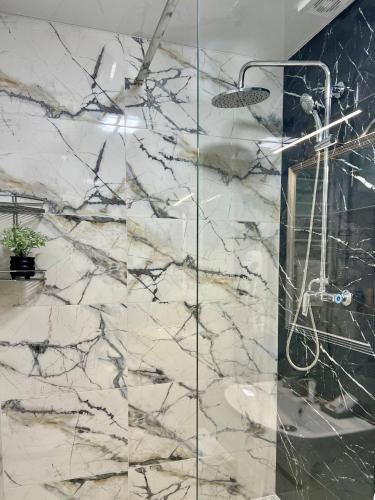 a marble bathroom with a shower with a glass wall at apartments in Ternopil city in Ternopilʼ
