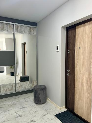 a room with a door and a stool and a mirror at apartments in Ternopil city in Ternopilʼ